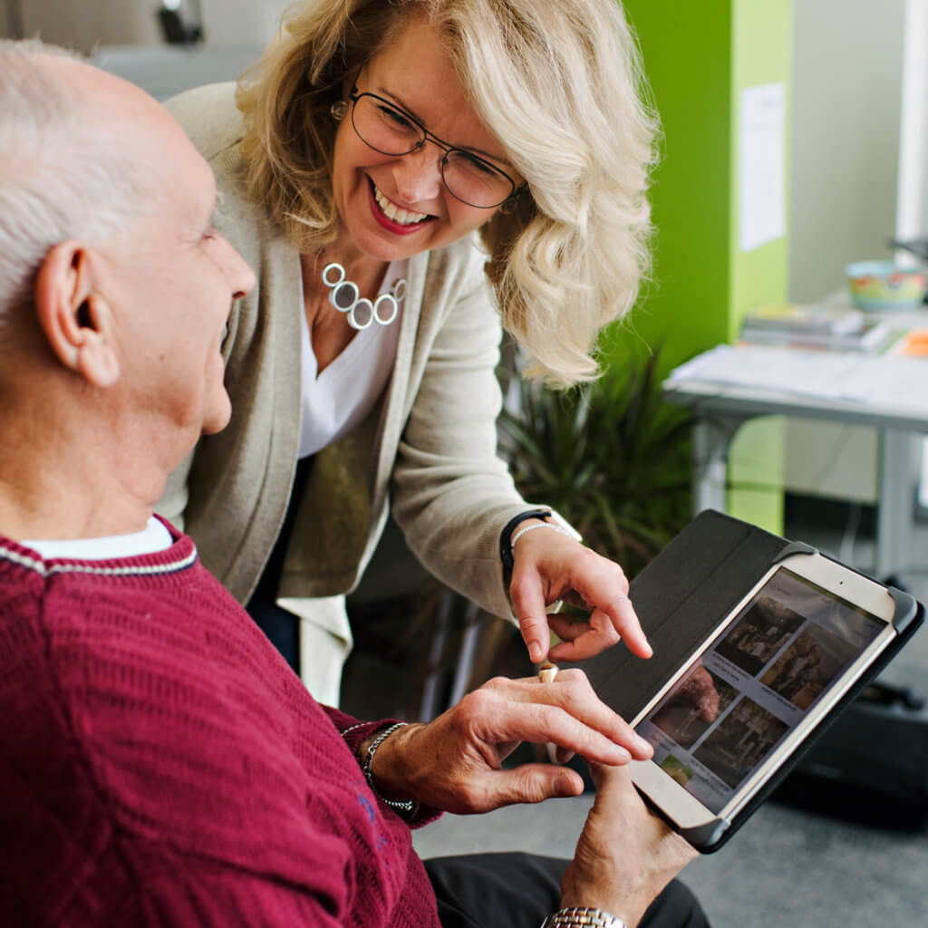 Mary Pat helping elderly client use MemorySparx tool on Ipad